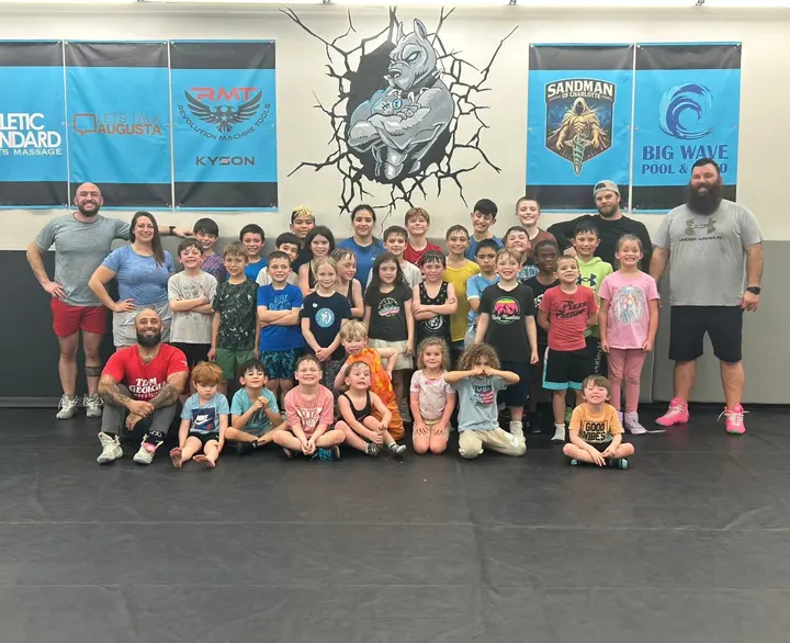 Backyard Bullies coaches and young wrestlers gathered together in the club's training room