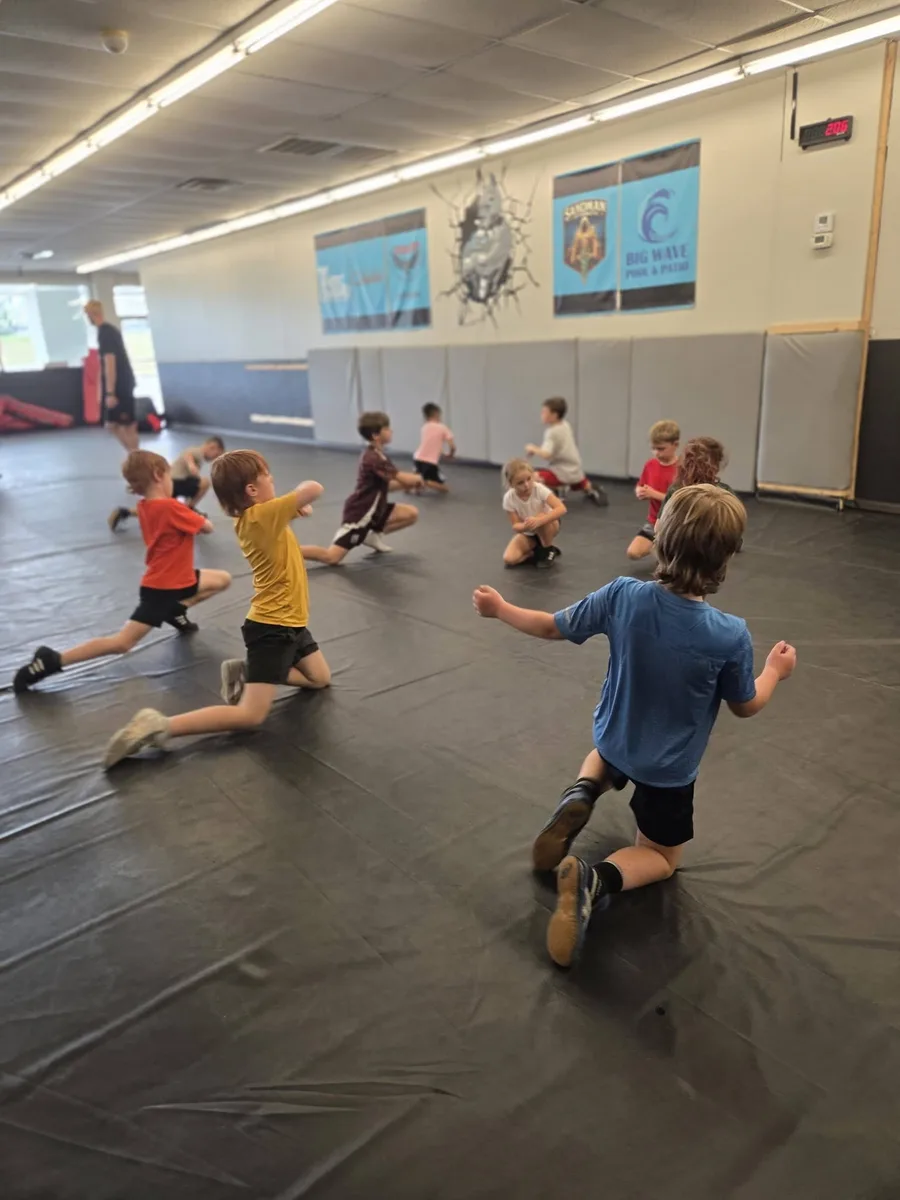 Young wrestlers practicing together on the mat at Backyard Bullies Wrestling Club
