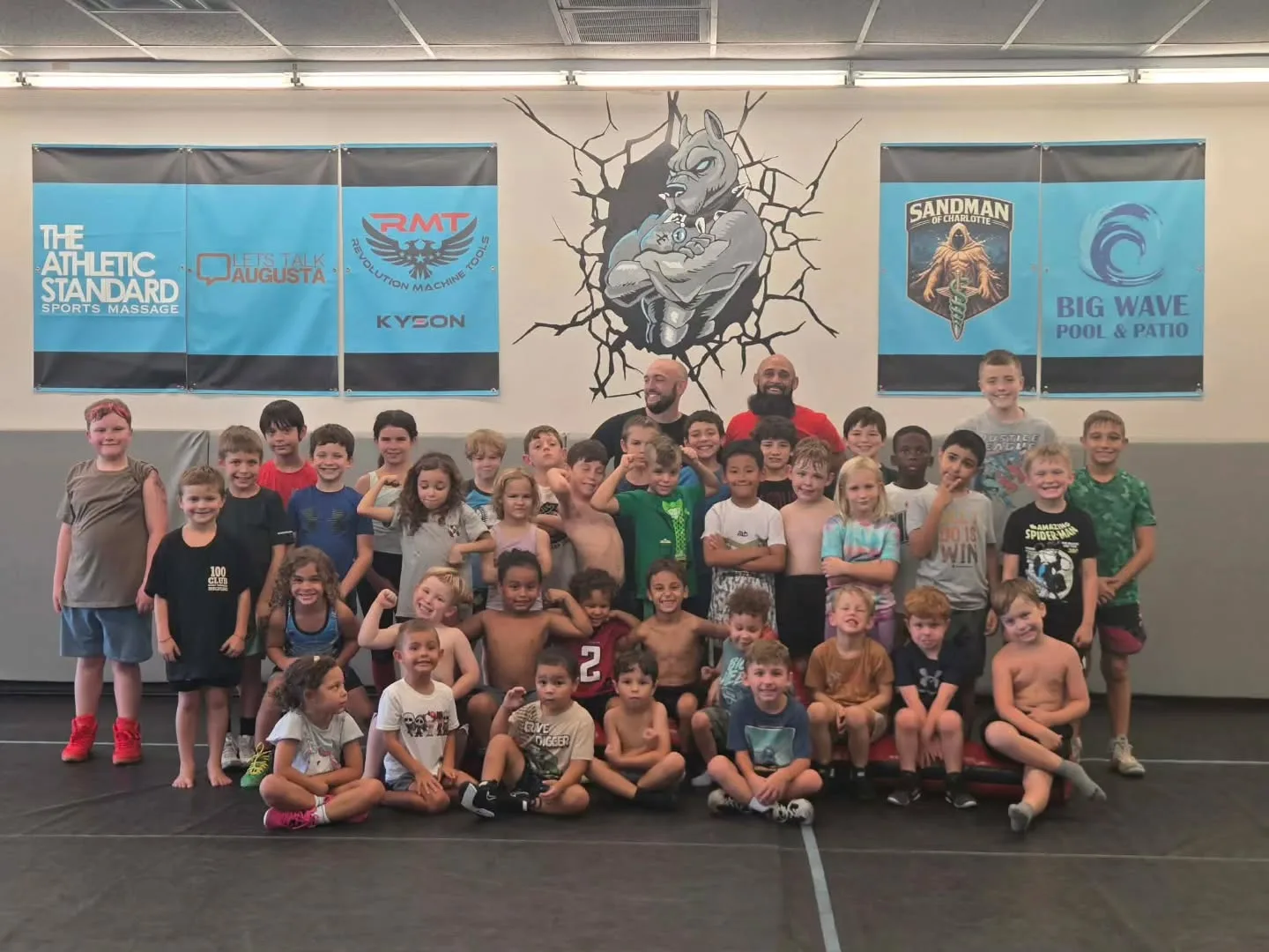 Backyard Bullies youth wrestlers and coaches pose for a team photo in the Augusta gym